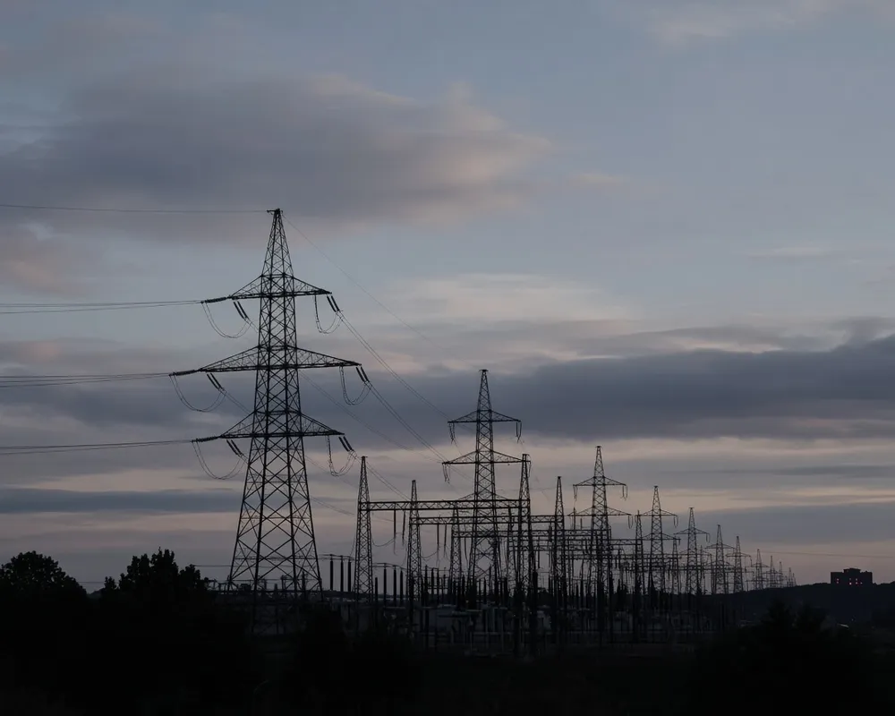Editorial photograph of transmission lines against a pale sky